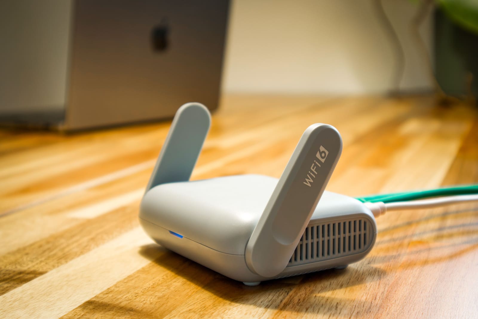 A Wi-Fi router with antennas on a wooden desk