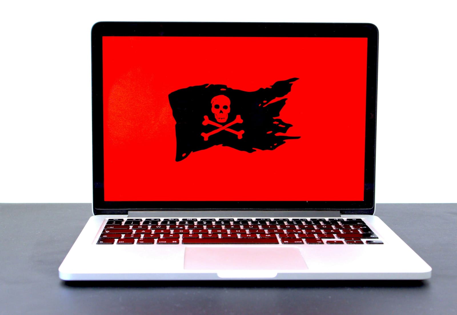 A laptop open in a dim room, the screen the only light source