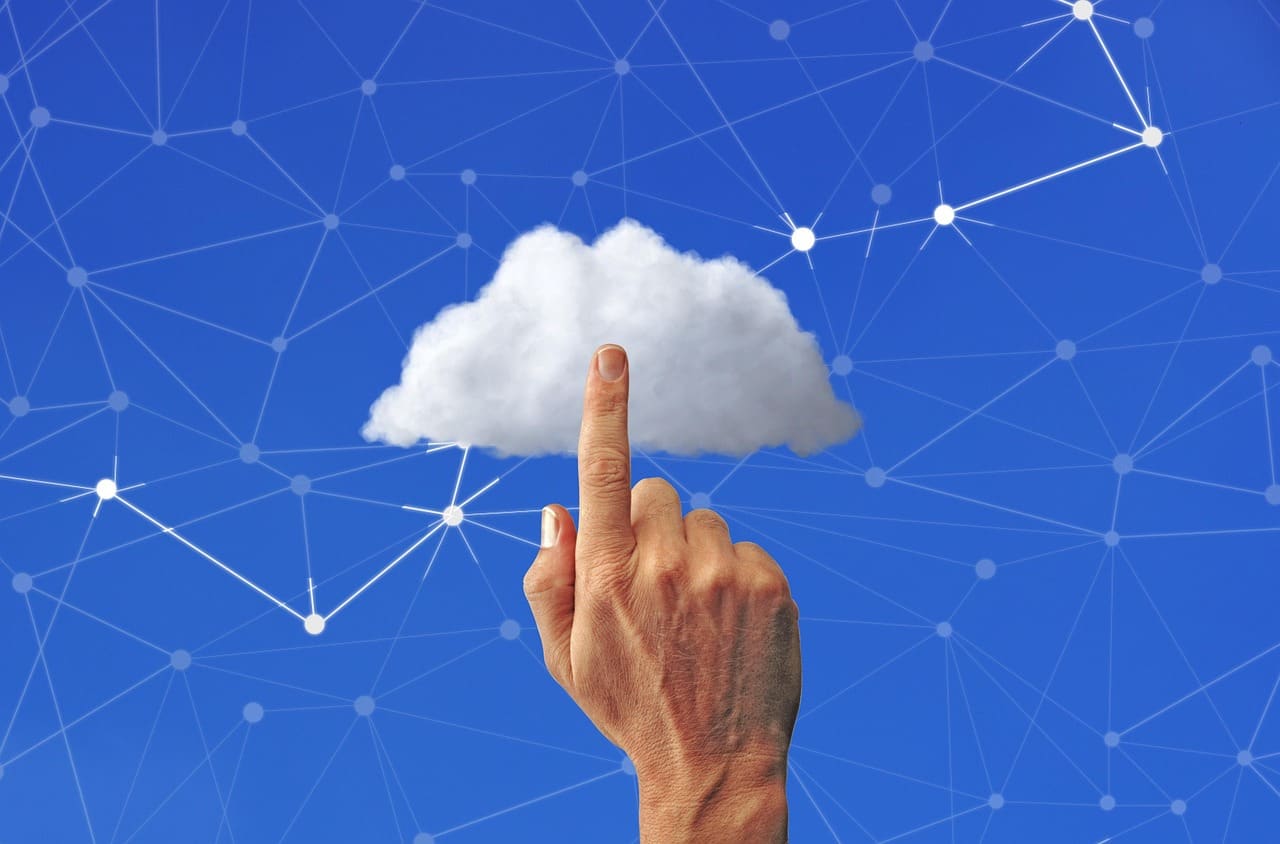 A hand reaching toward a glowing digital cloud network icon